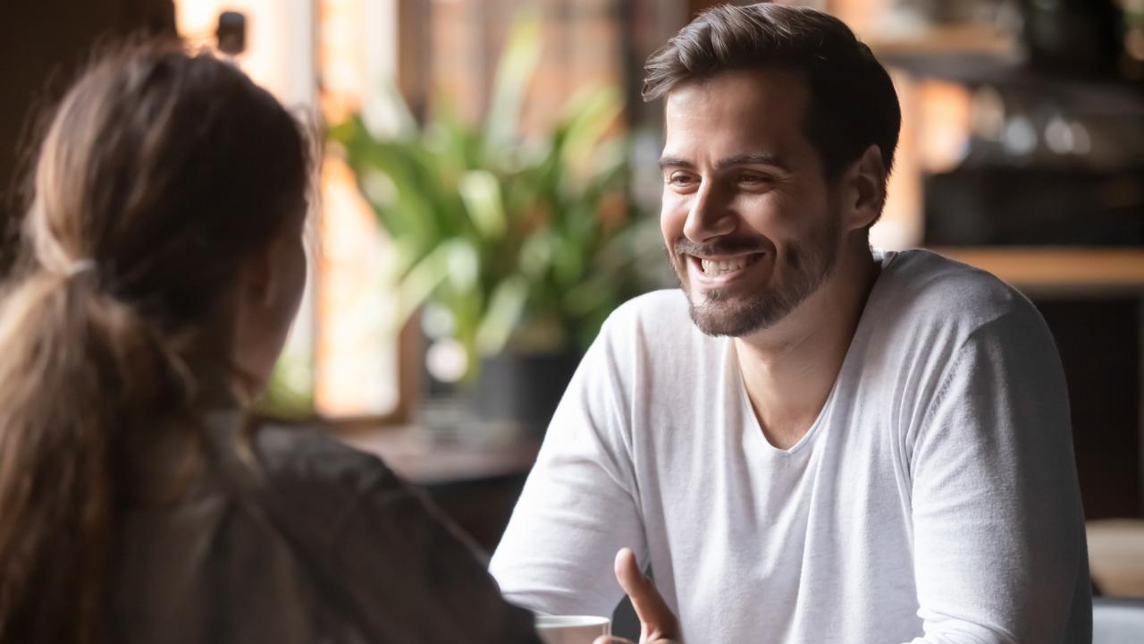 Young woman and man on a speed date sitting at table