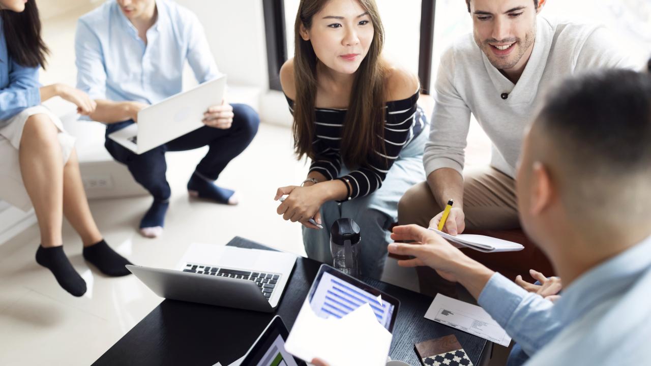 Students sitting in informal meeting with laptops