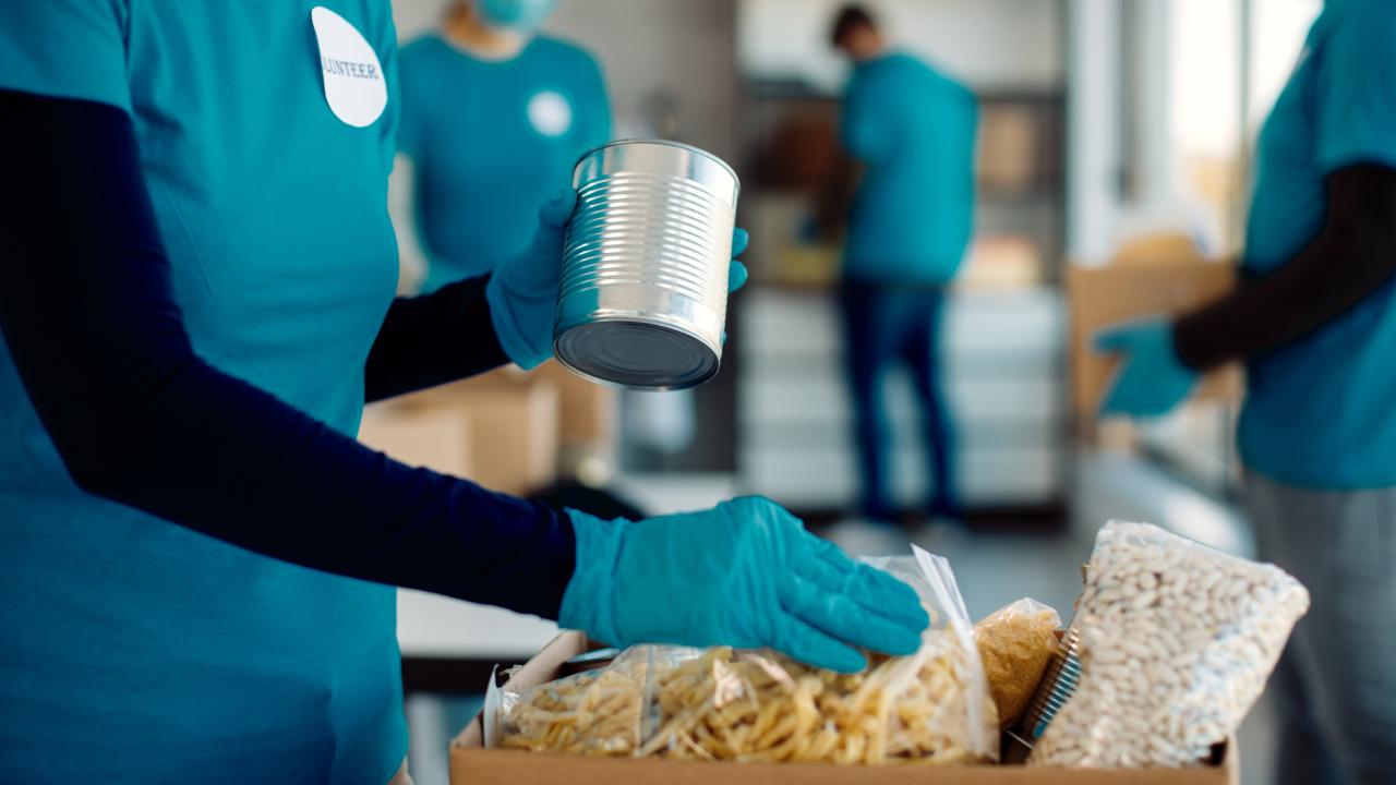 People, with no faces showing, fills boxes of groceries