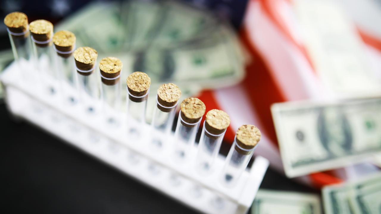 Photo illustration with test tubes and American currency.