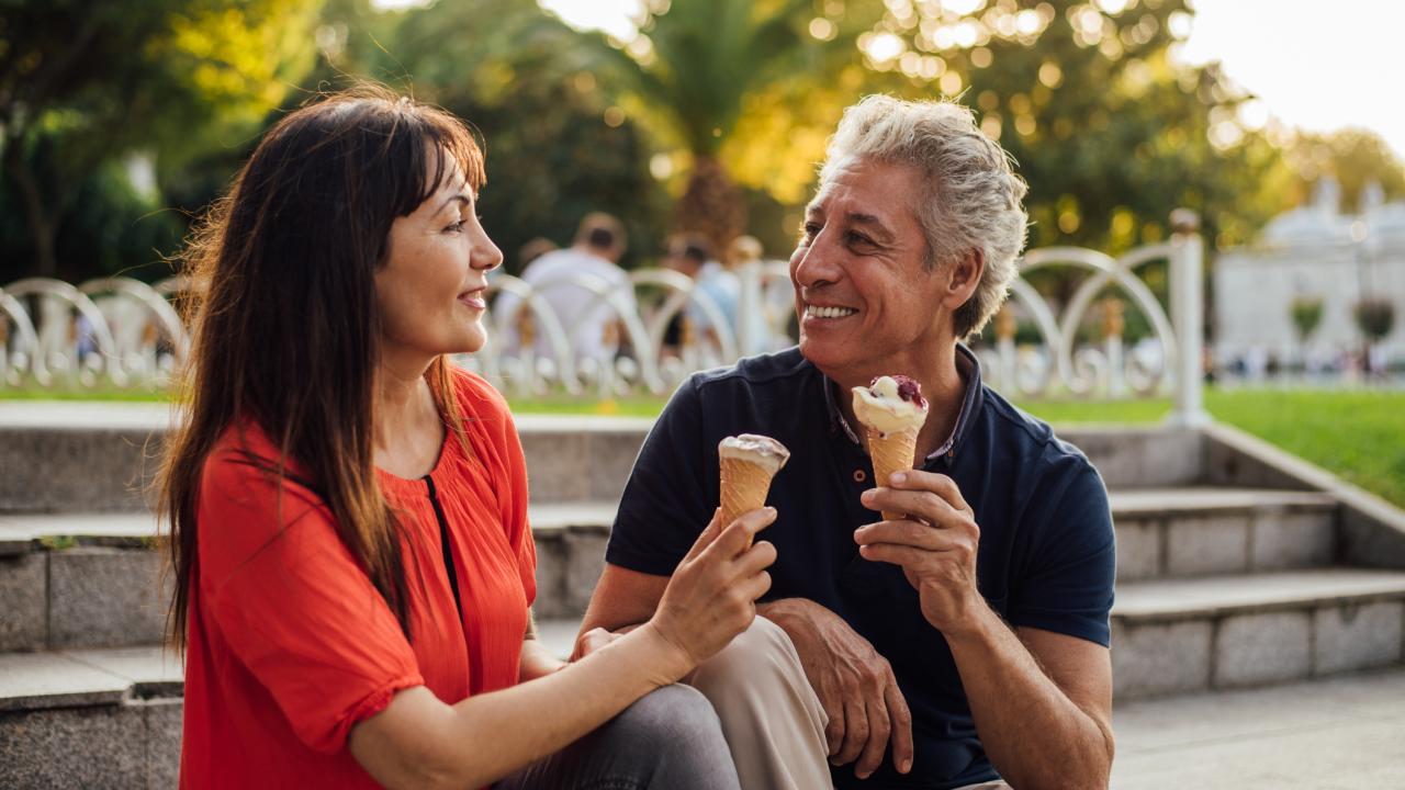 Couple having ice cream cones at park
