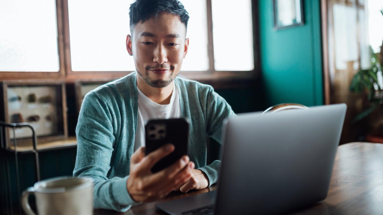 portrait of man looking at phone with window and door behind him