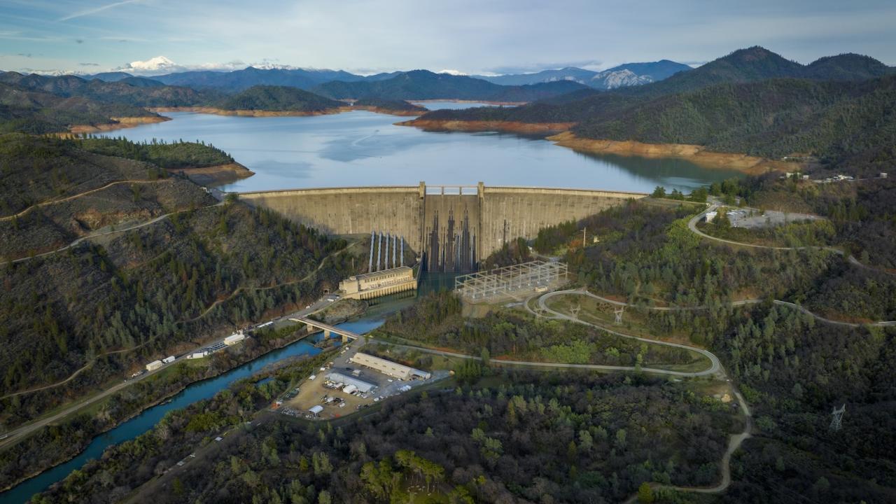 Drone image of rain-soaked Shasta Dam and mountains and streams around it