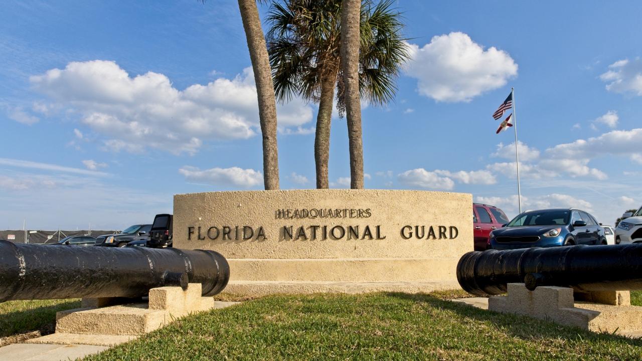 Photo of National Guard headquarters in Florida showing cement building, palm trees and blue sky