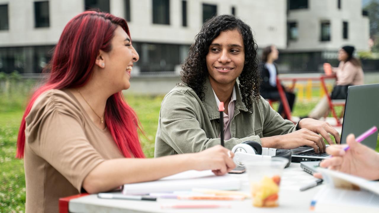 Students conversing at table on university campus