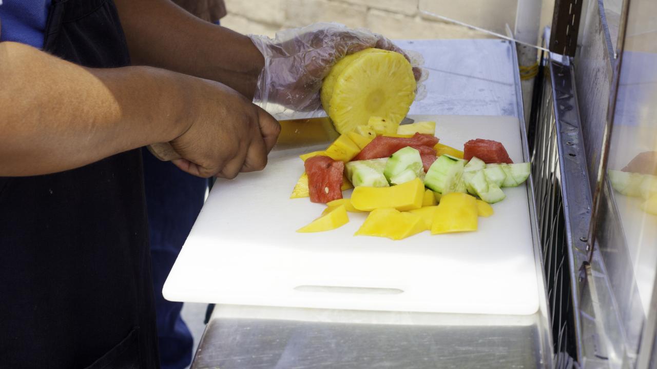 Street vendor cutting food. 