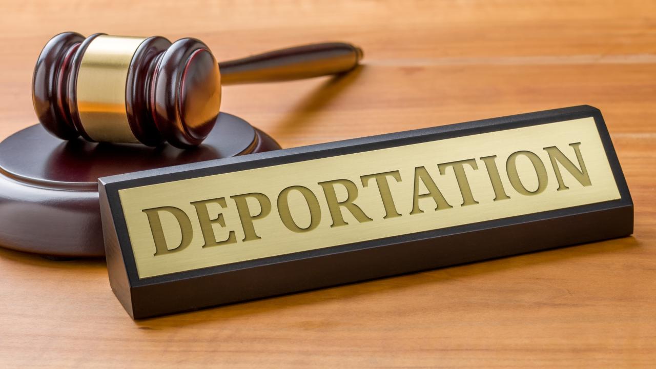 Judicial gavel on desk next to word "deportation" on a name plate