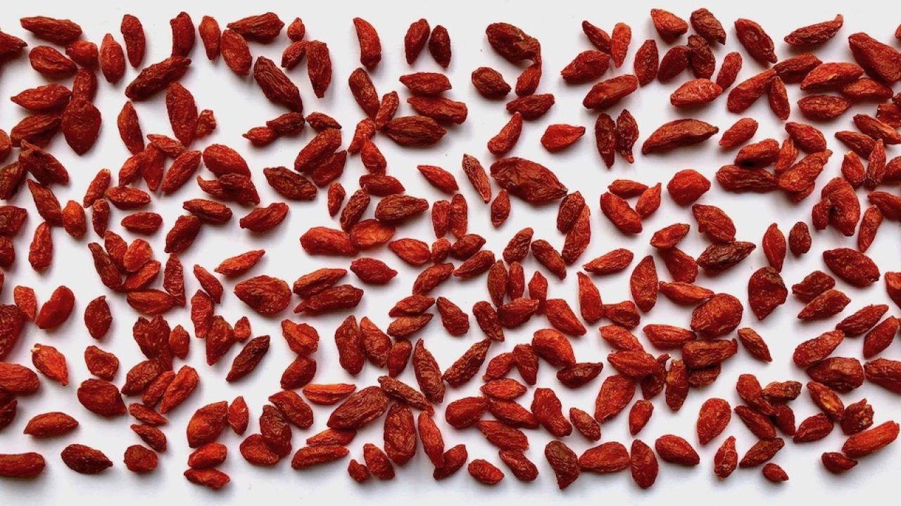 Dried red goji berries against white background