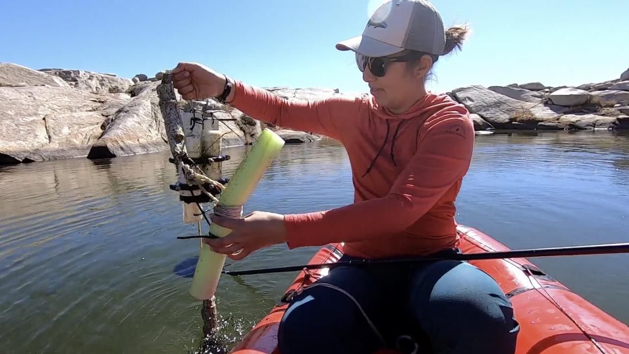 MJ Farruggia samples water in an alpine pond