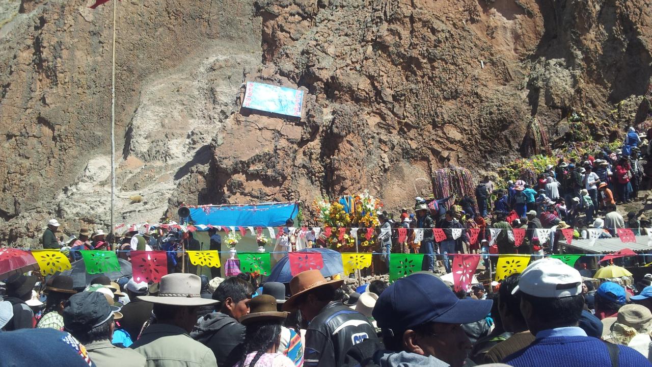 People gathering at rocky sanctuary site in Peru.