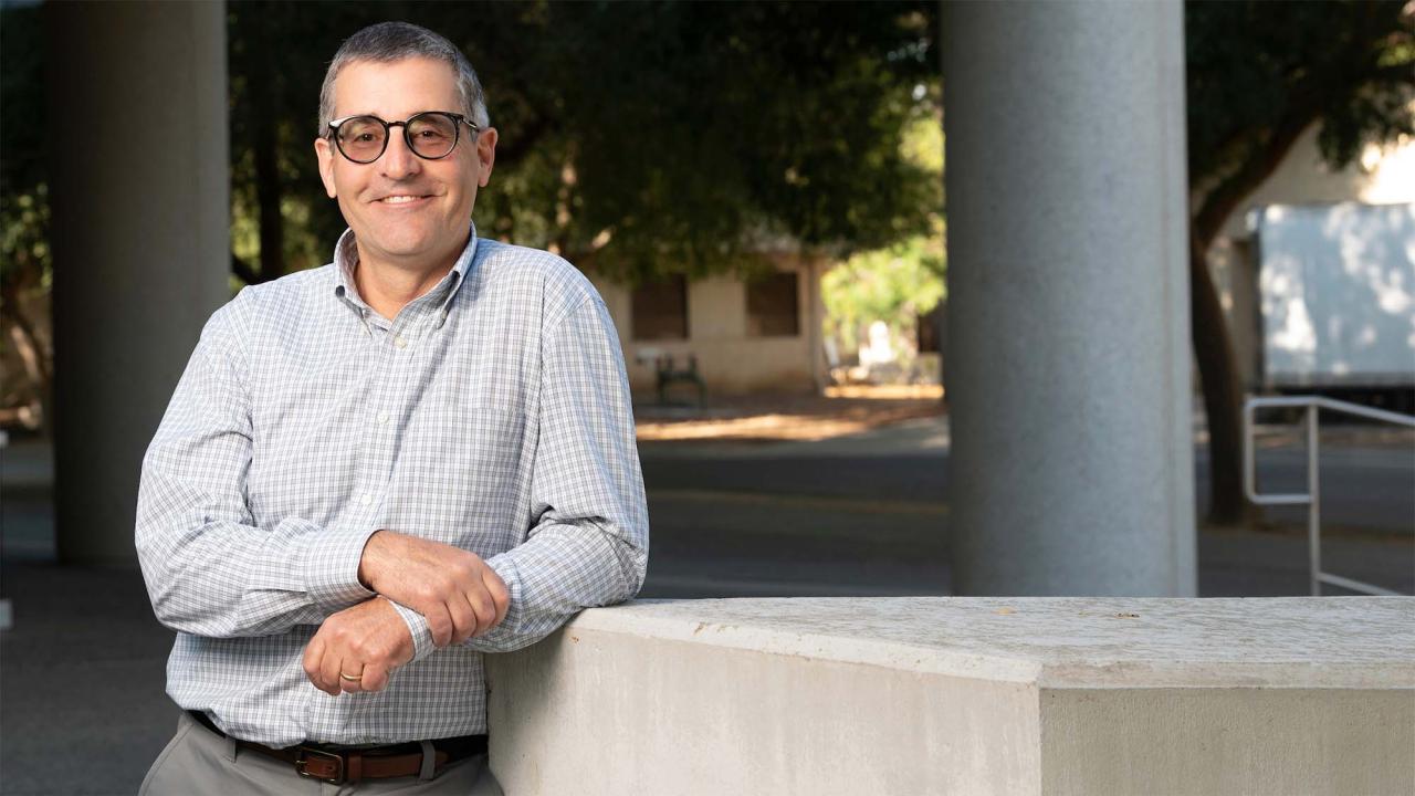 Ross Boulanger leaning against a concrete block outdoors