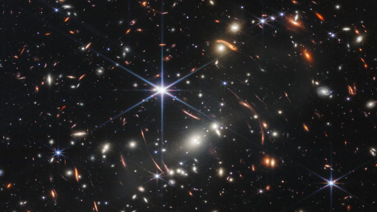 Hundreds of stars and galaxies against a black background