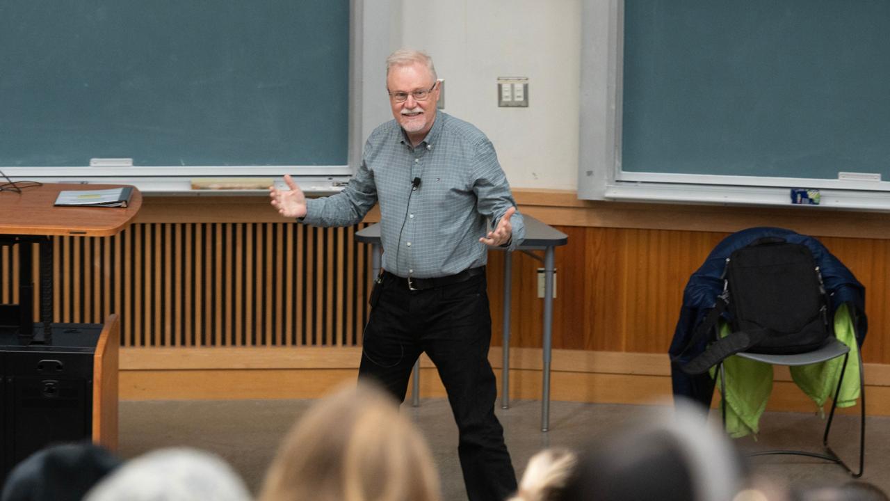 Steven Luck stands with arms wide as he teaches in a class