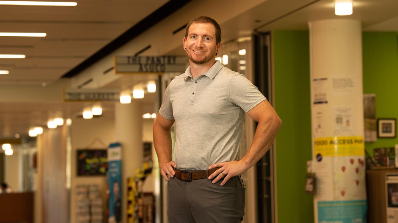 Man stands in hallway with hands on hips
