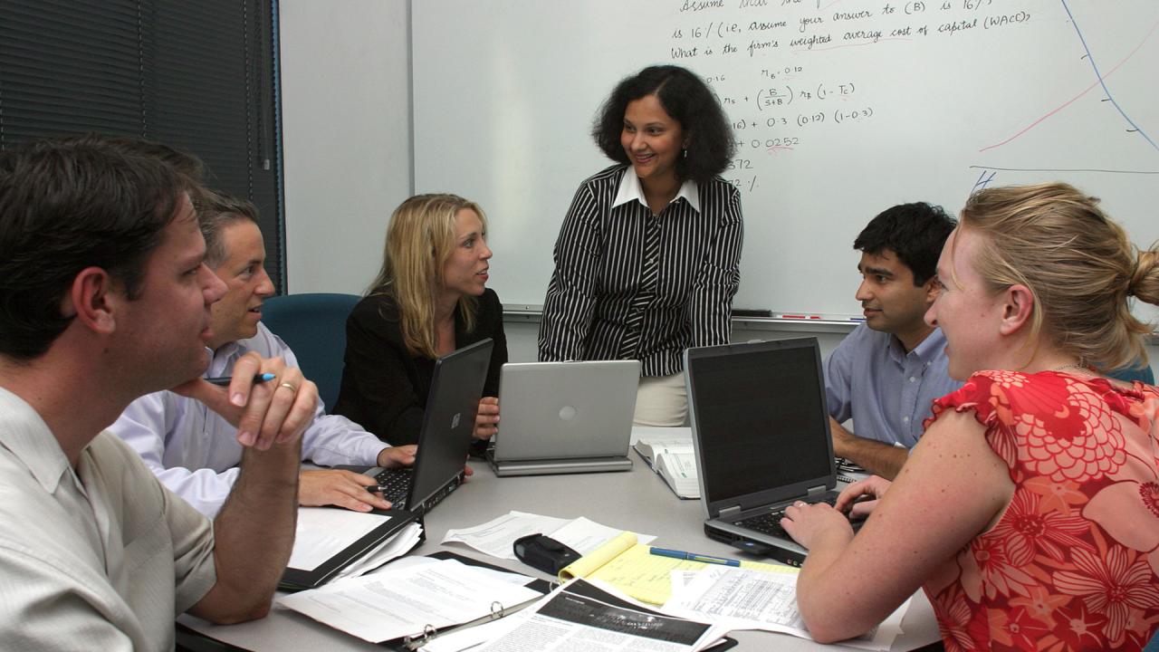 Woman stands in front of small class group