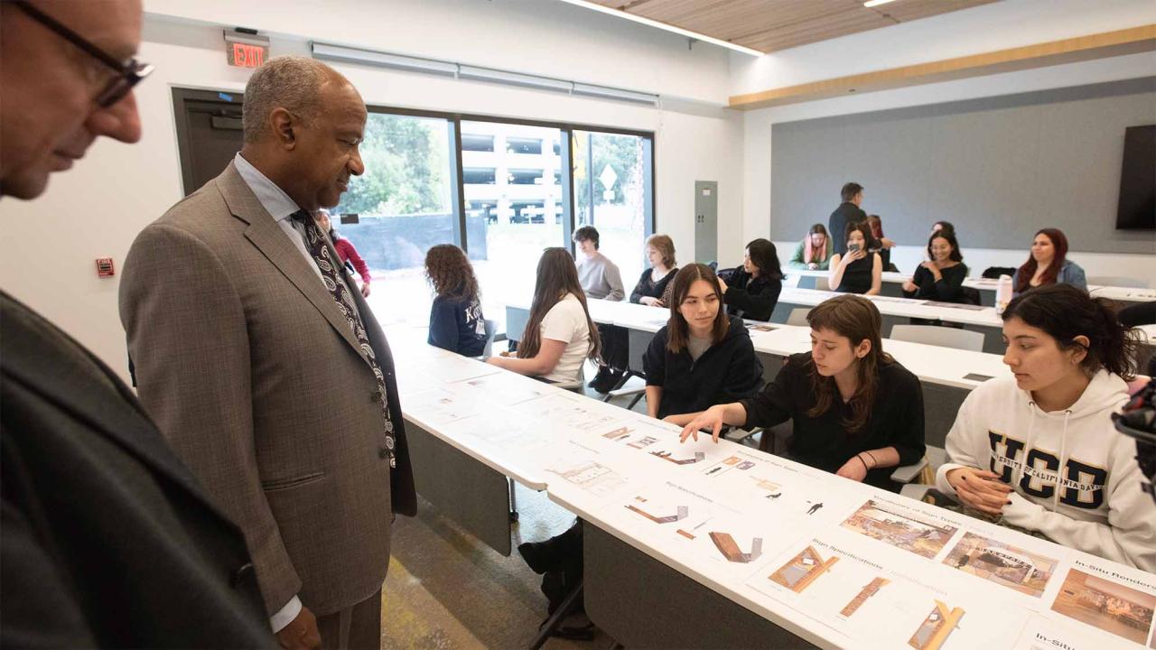 Chancellor Gary S. May looks at student designs for wayfinding signs and other designs for Aggie Square.
