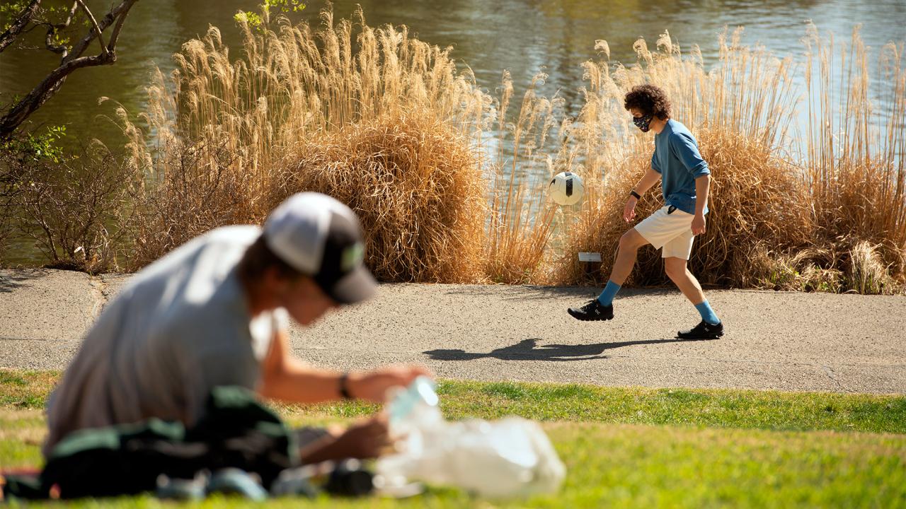Student juggles soccer ball with feet.