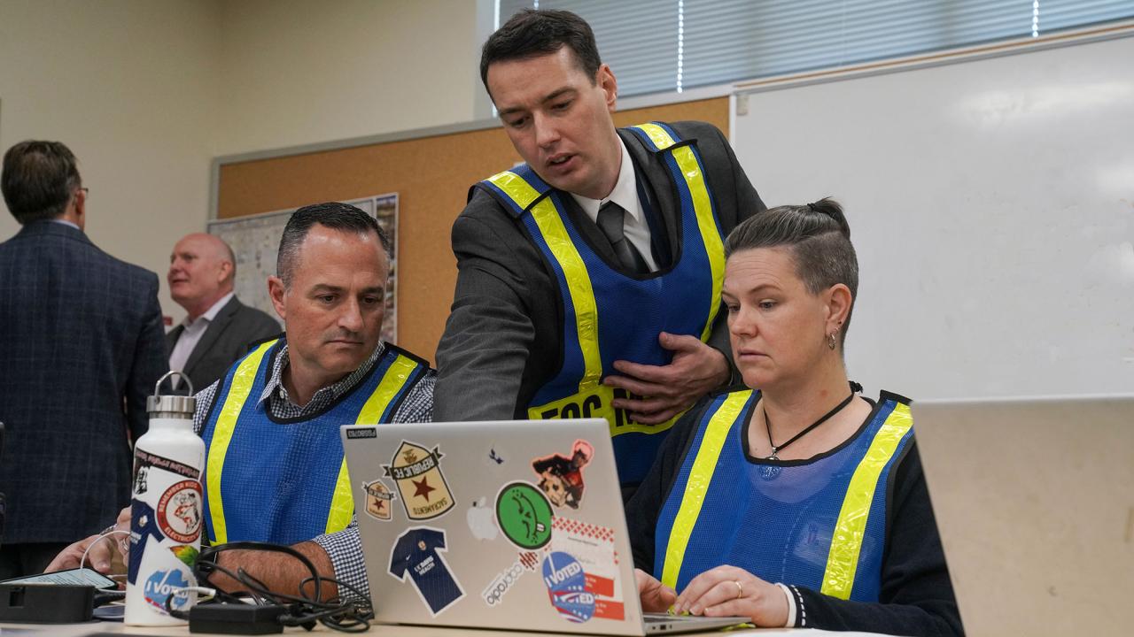 Benton Best and two others confer at a computer
