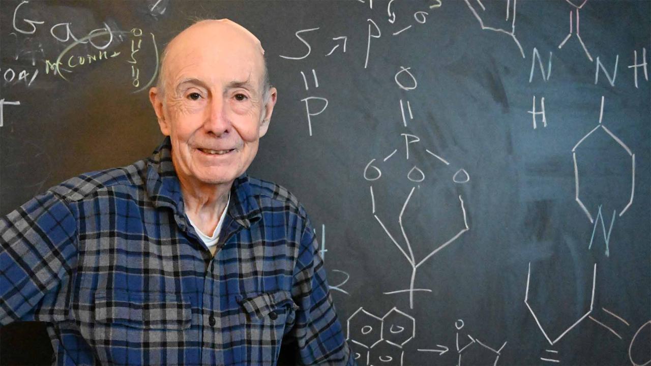 Bruce Hammock stands in front of a chalkboard