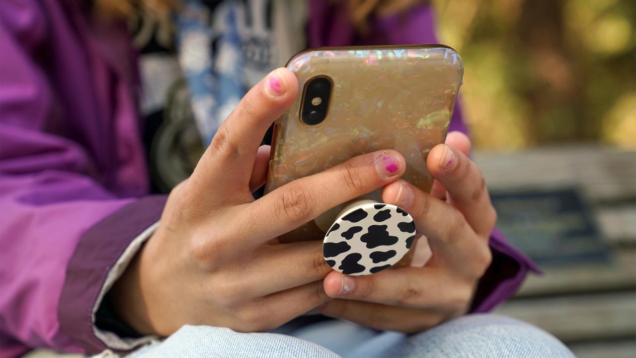 Hands hold a cell phone.