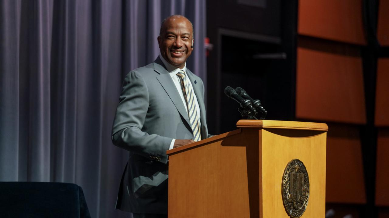 Chancellor Gary S. May, smiling, at lectern