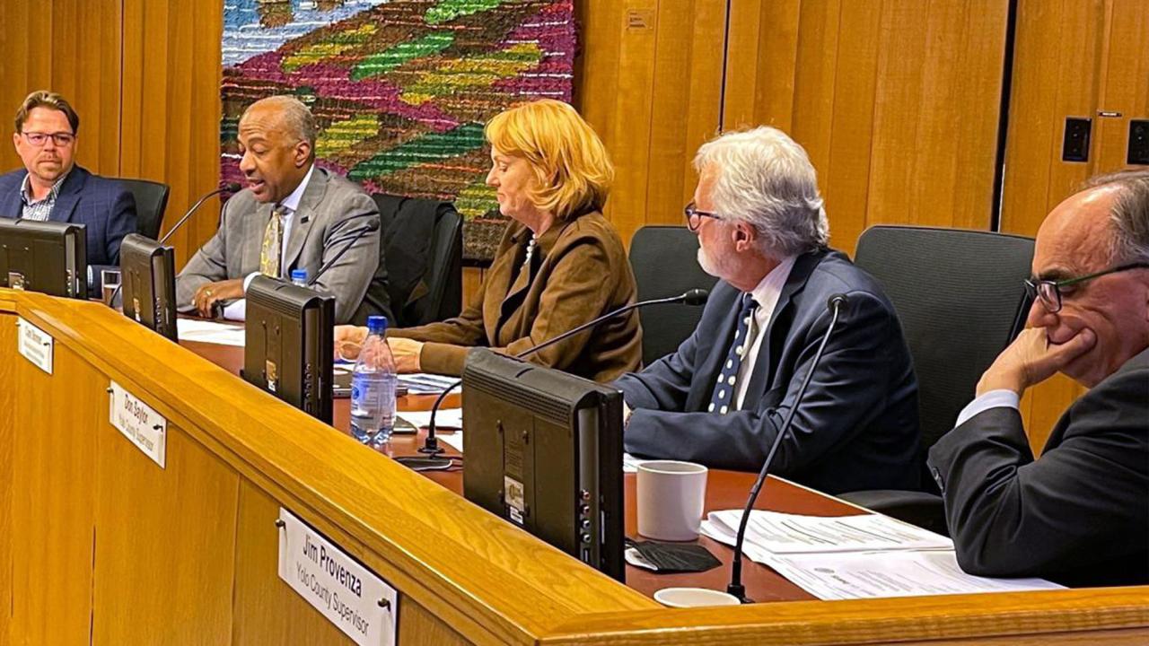 Four men, one woman at dais