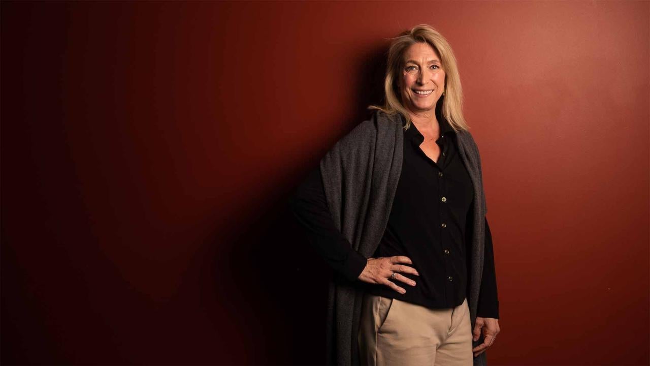 Christine Kreuder Johnson poses for photo in front of red wall