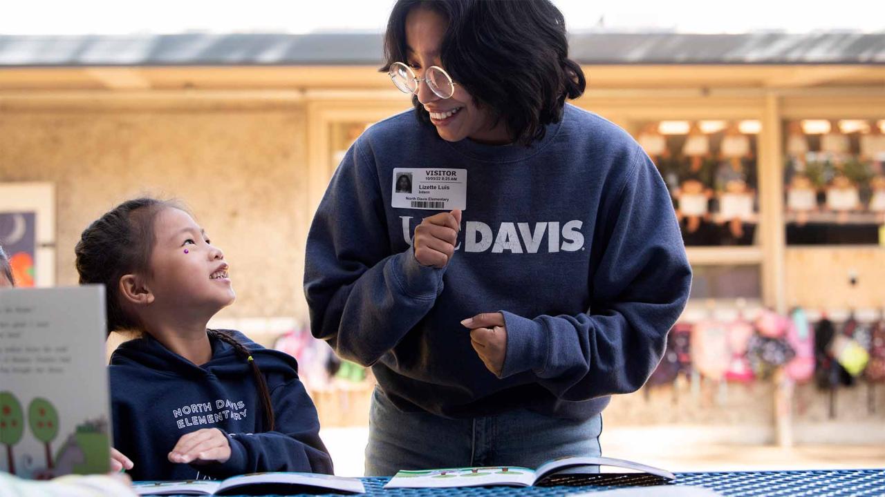 Student reads to young child