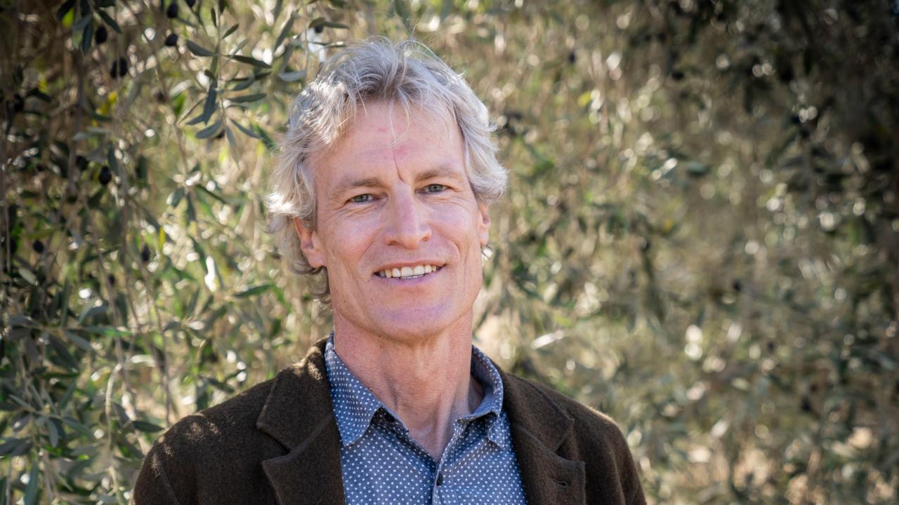 Dan Flynn. environmental portrait, olive trees as background