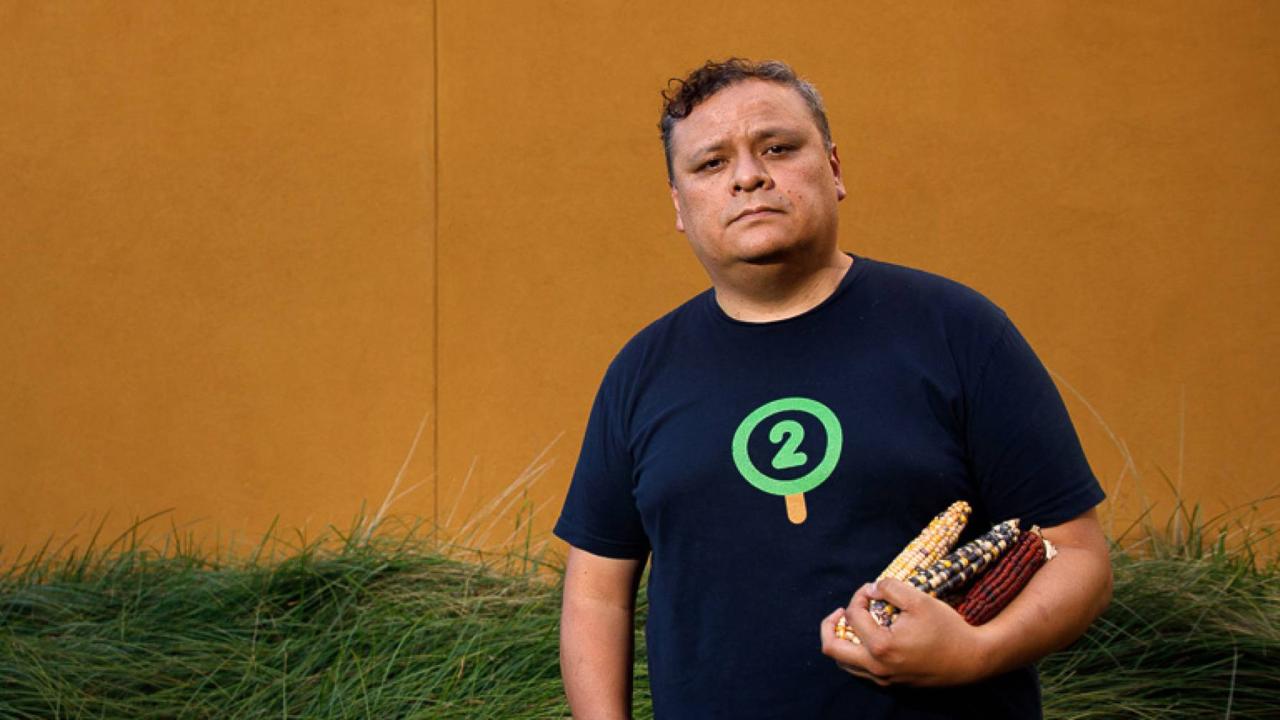 Man holds maize in environmental portrait
