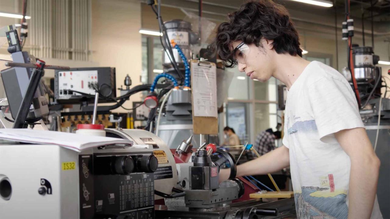Student works at machine in design center.