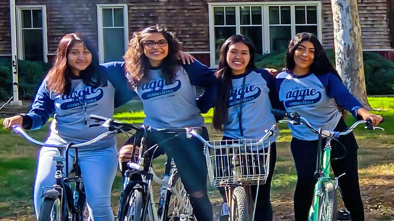 Four female students, posing, on bikes.