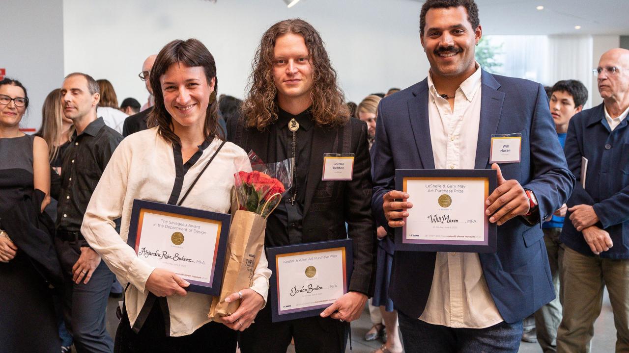Three people holding award plaques with crowd in background in the Mondavi lobby of Manetti Shrem Museum, UC Davis