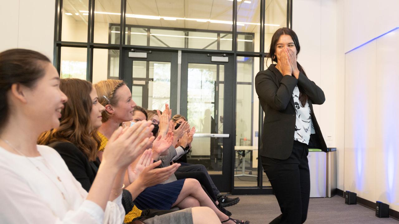 Woman holds hands to mouth, expressing surprise