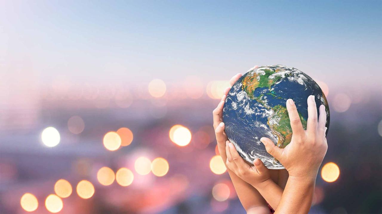 Hands holding up planet Earth.