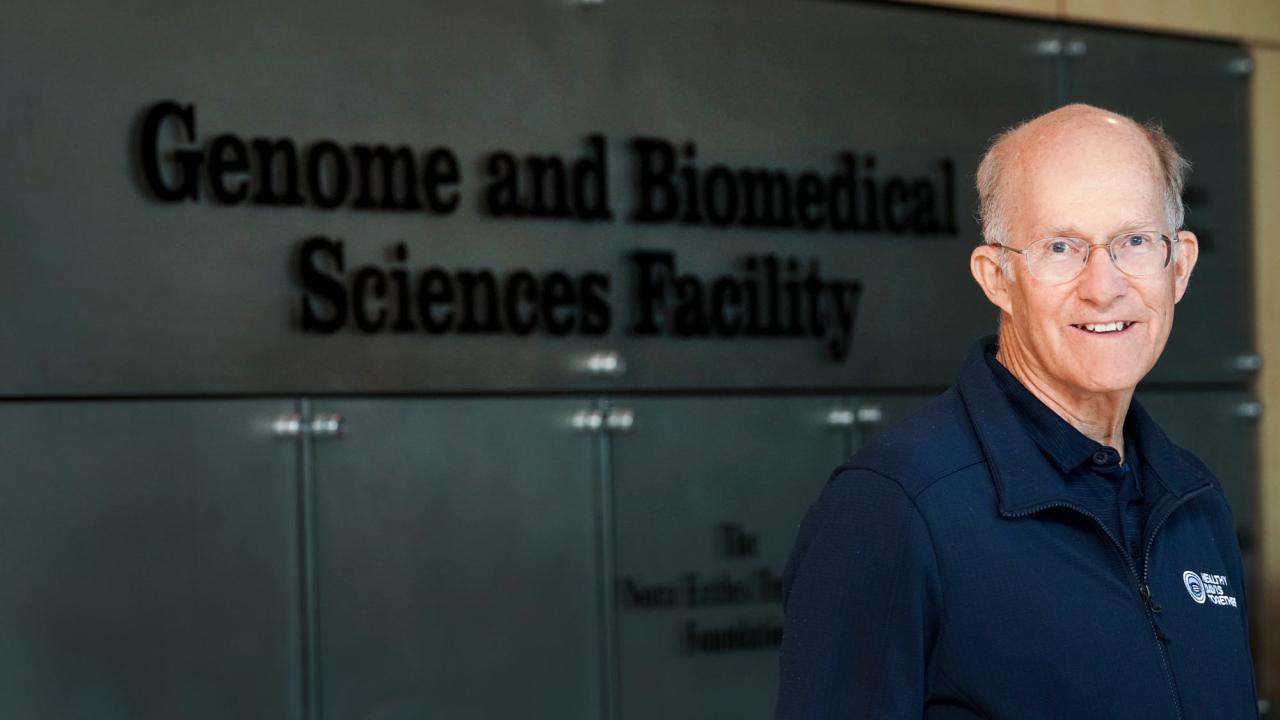 Ken Burtis, unmasked, outside, in front of sign on building: "Genome and Biomedical Science Facility"