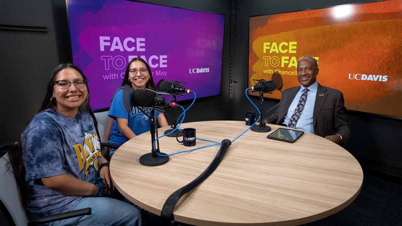 Identical twin students Vanessa and Victoria Liera pose for photo with Chancellor Gary S. May.