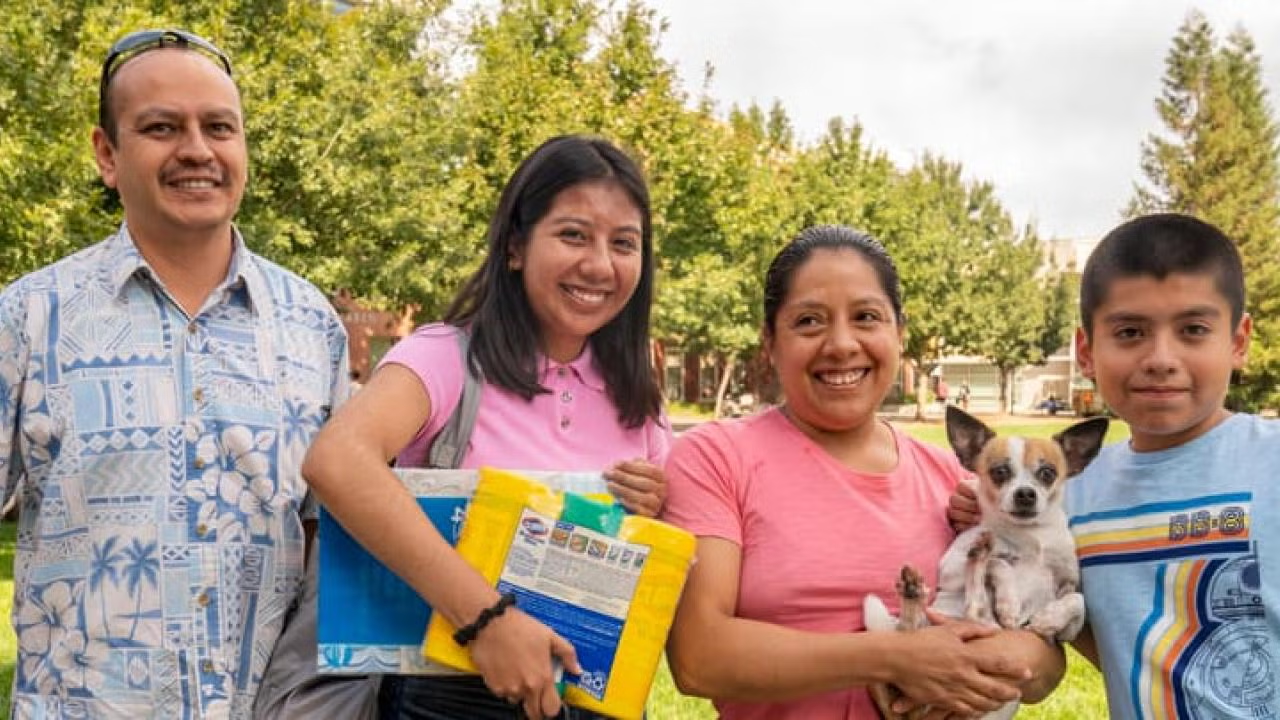 Family posing outside with their dog