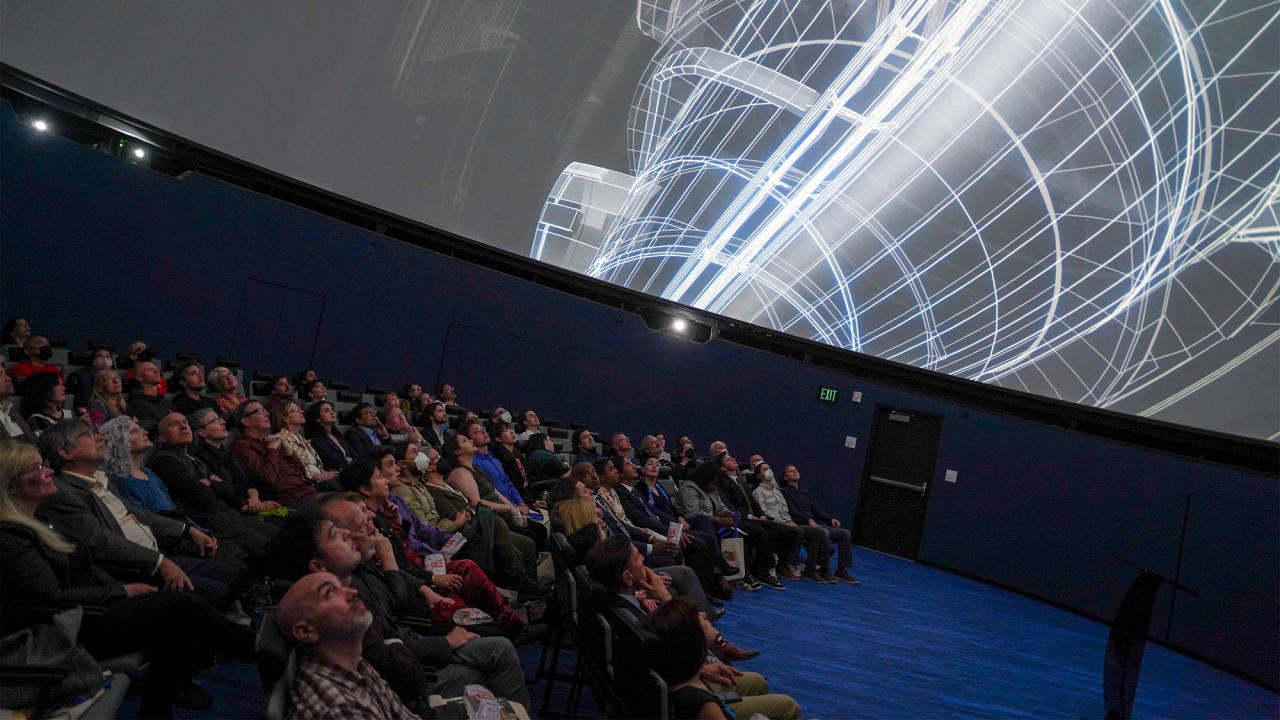 People watch a film in a planetarium. 