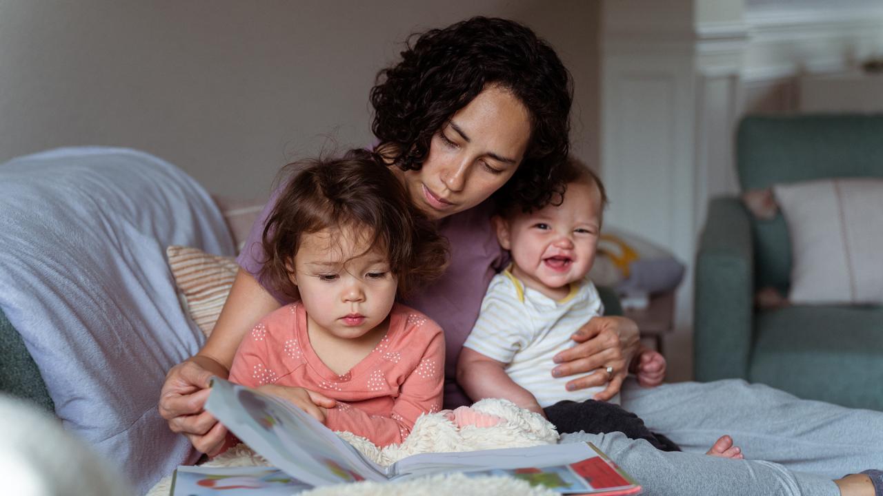 Mother reading to two toddlers 