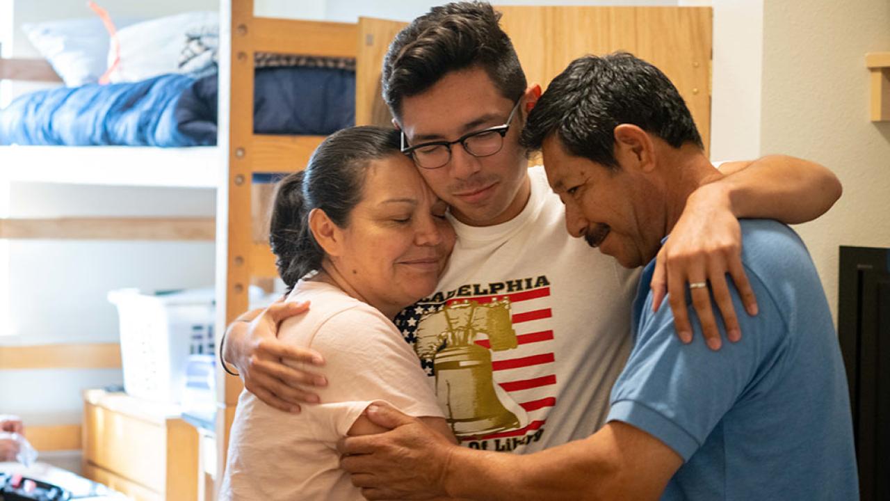 parents embrace student at move in day