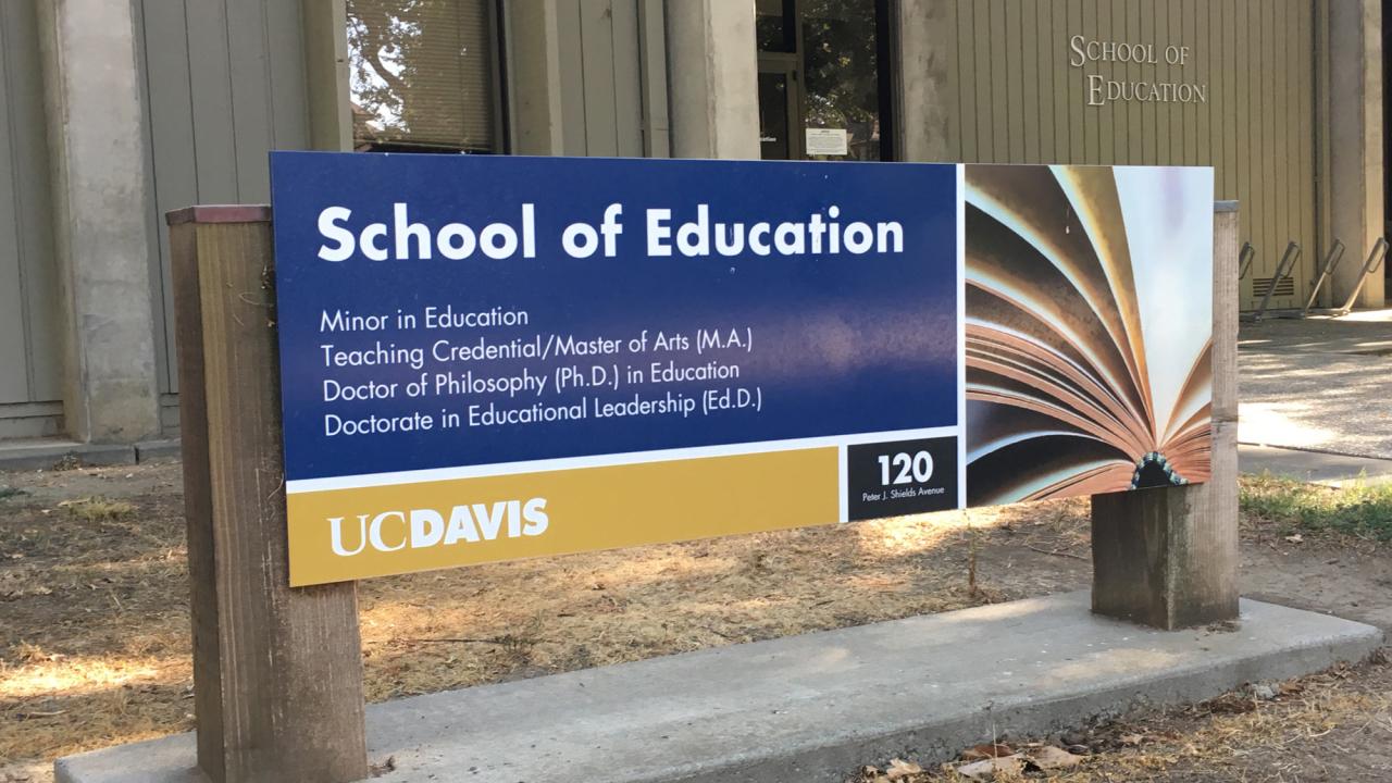 "School of Education" exterior sign featuring fanned pages of a book