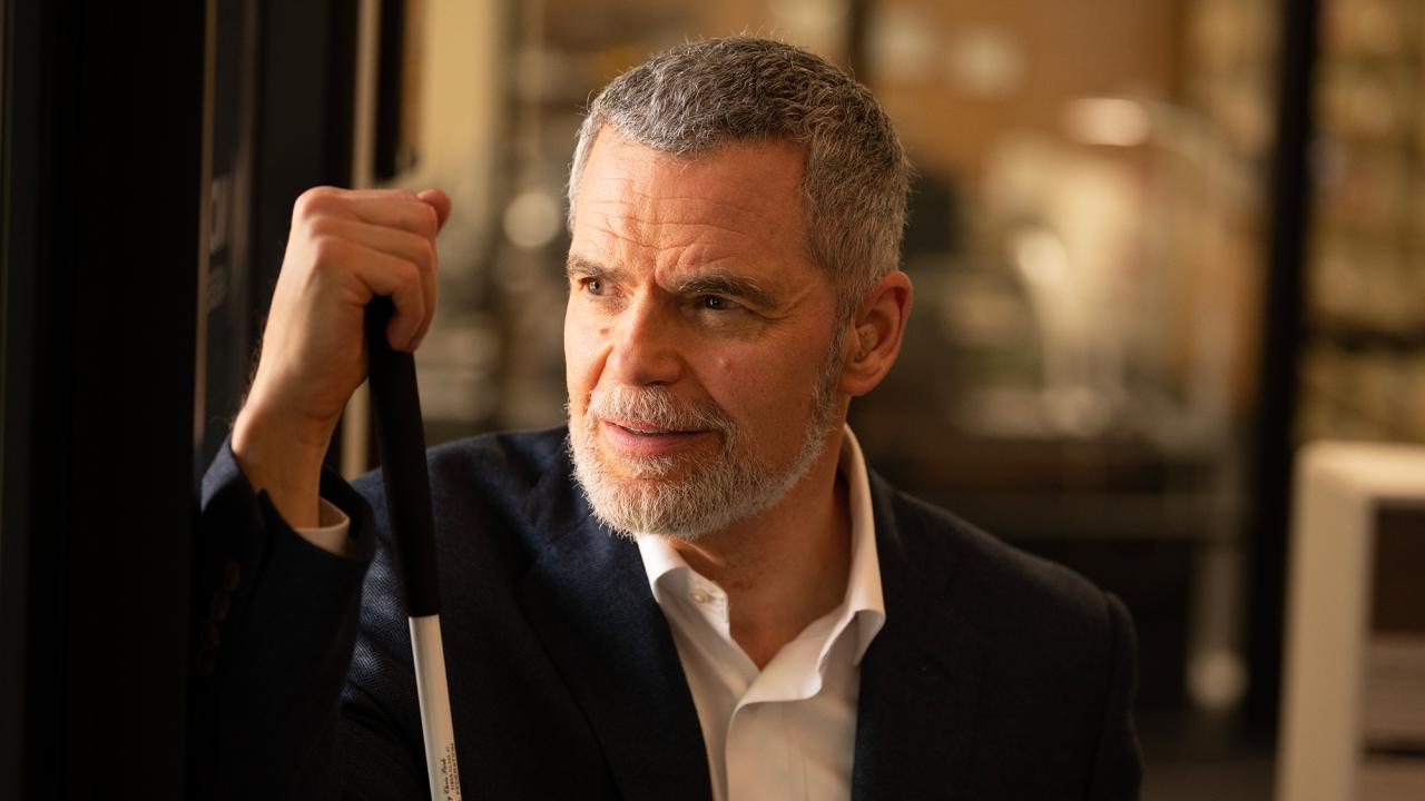 A man holds his can and looks into the distance