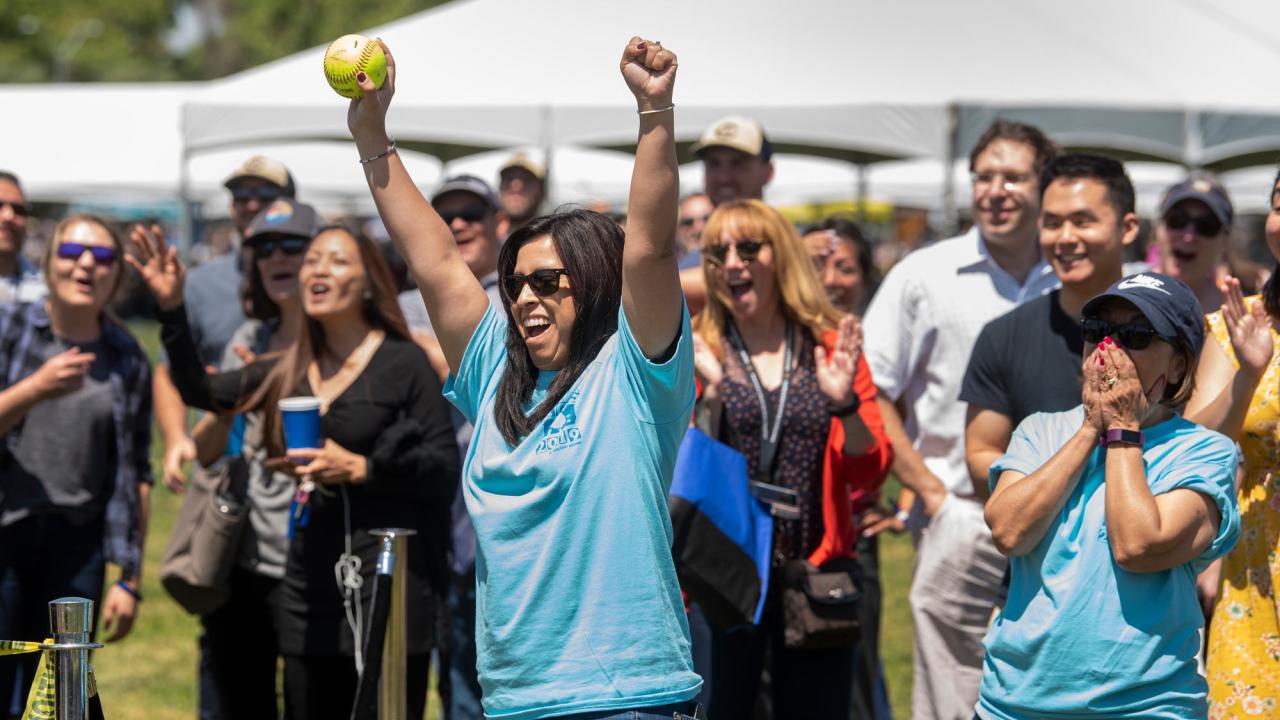 Woman raises arms in victory after dunking the chancellor