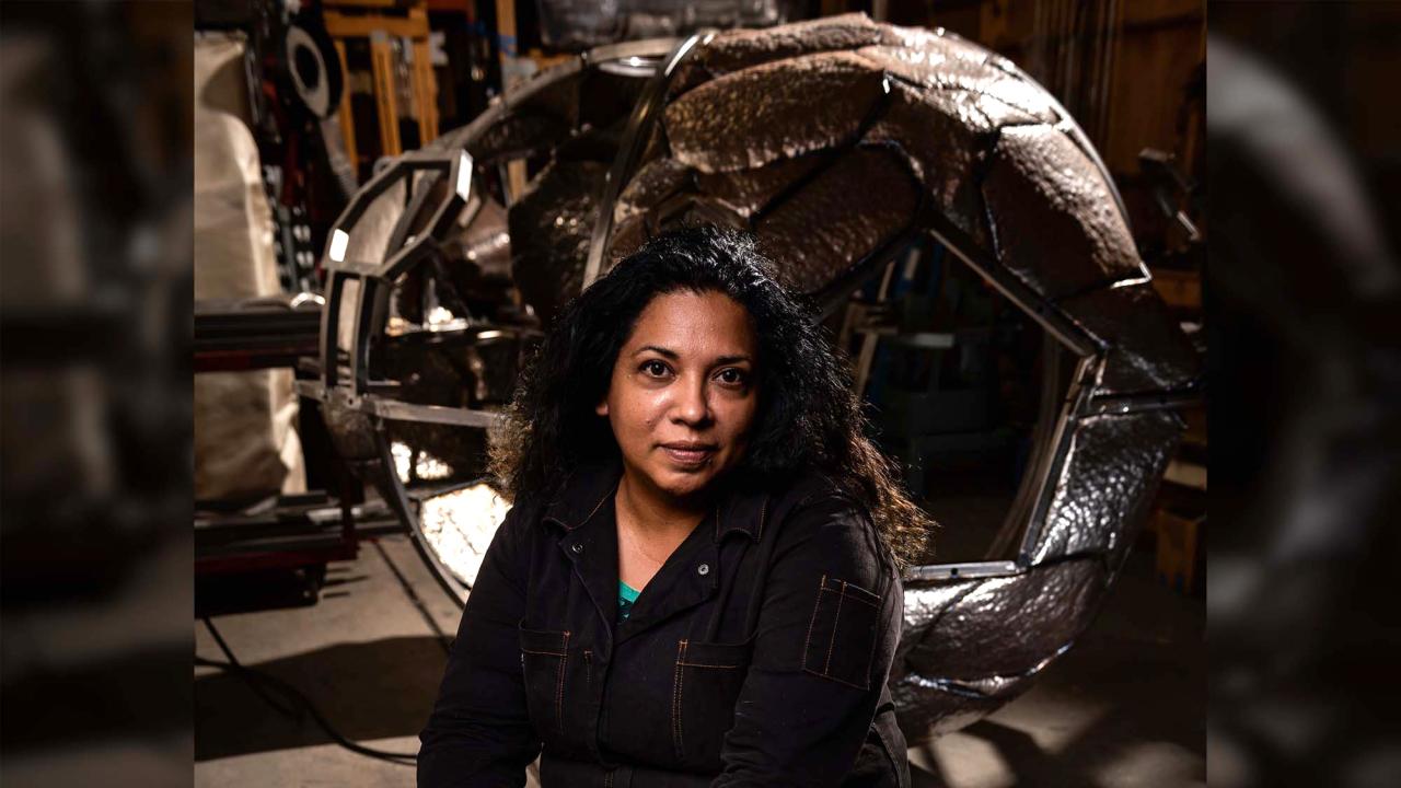 Woman in front of artwork on dark background