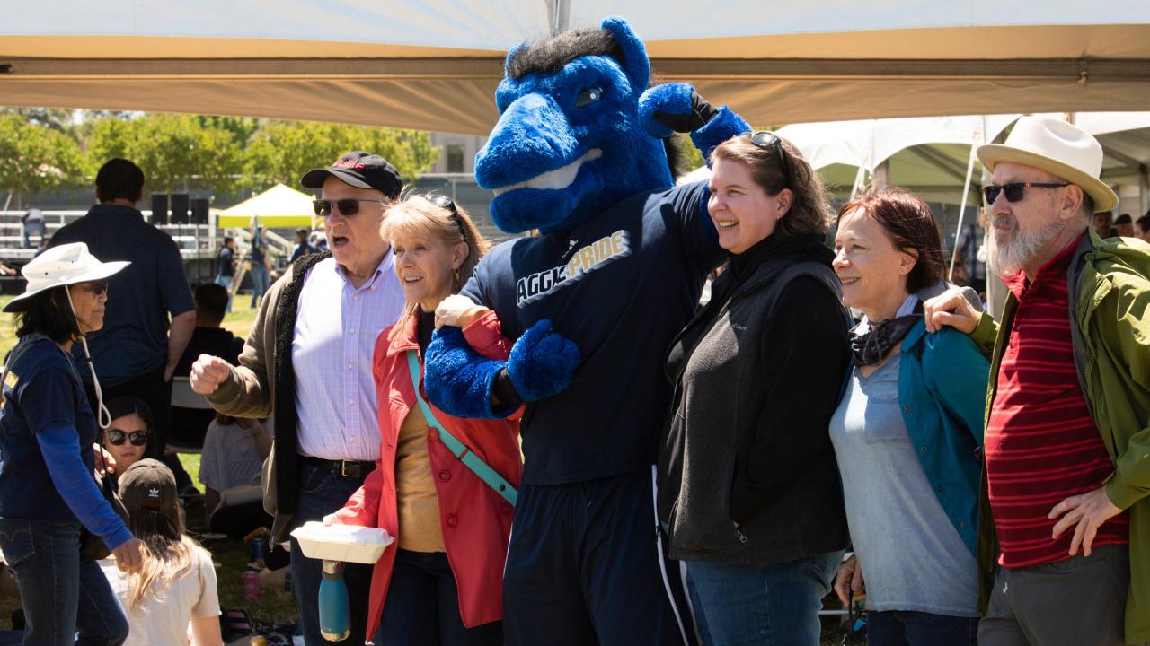 Gunrock flexes as he poses for a photo with four people