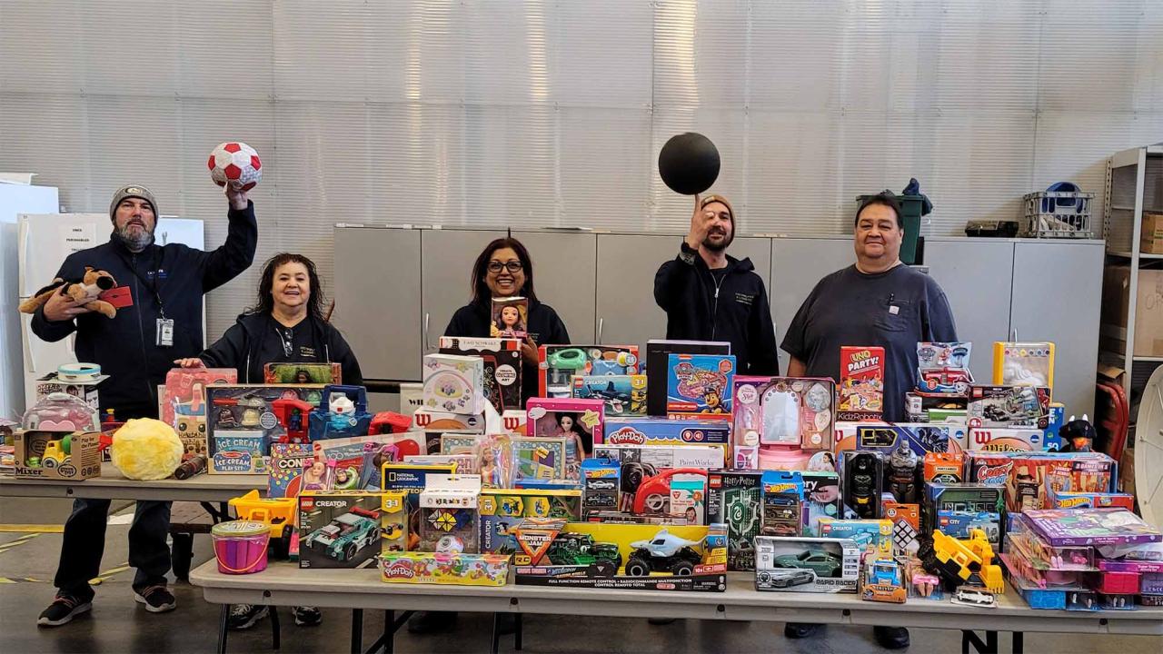 People stand in front of table of donated toys