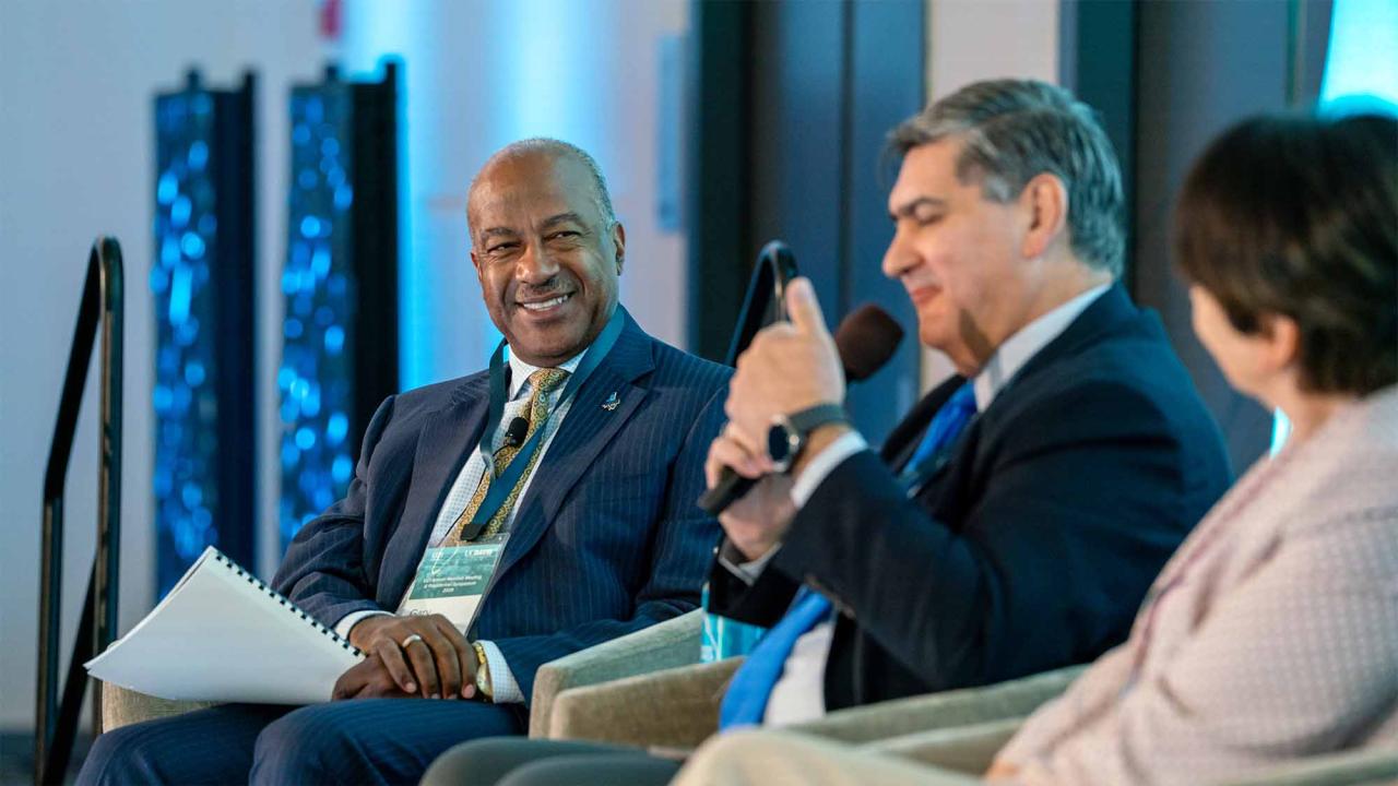 Chancellor Gary S. May looks on as David Garza speaks