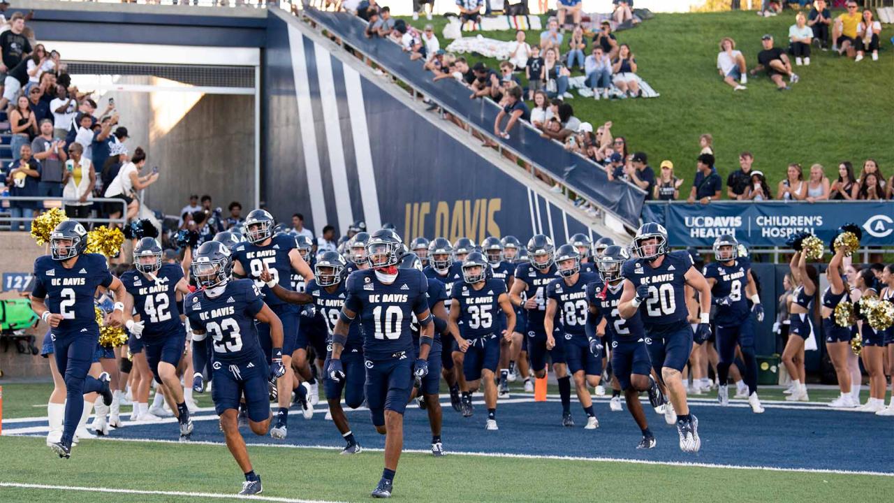 Members of the football team run onto the field