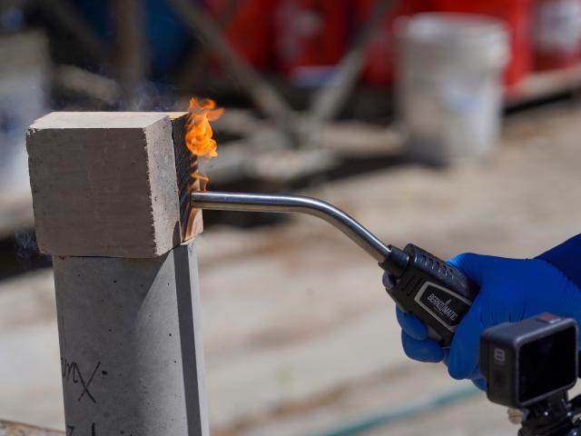 A close-up of a wood block and earth block and a blowtorch